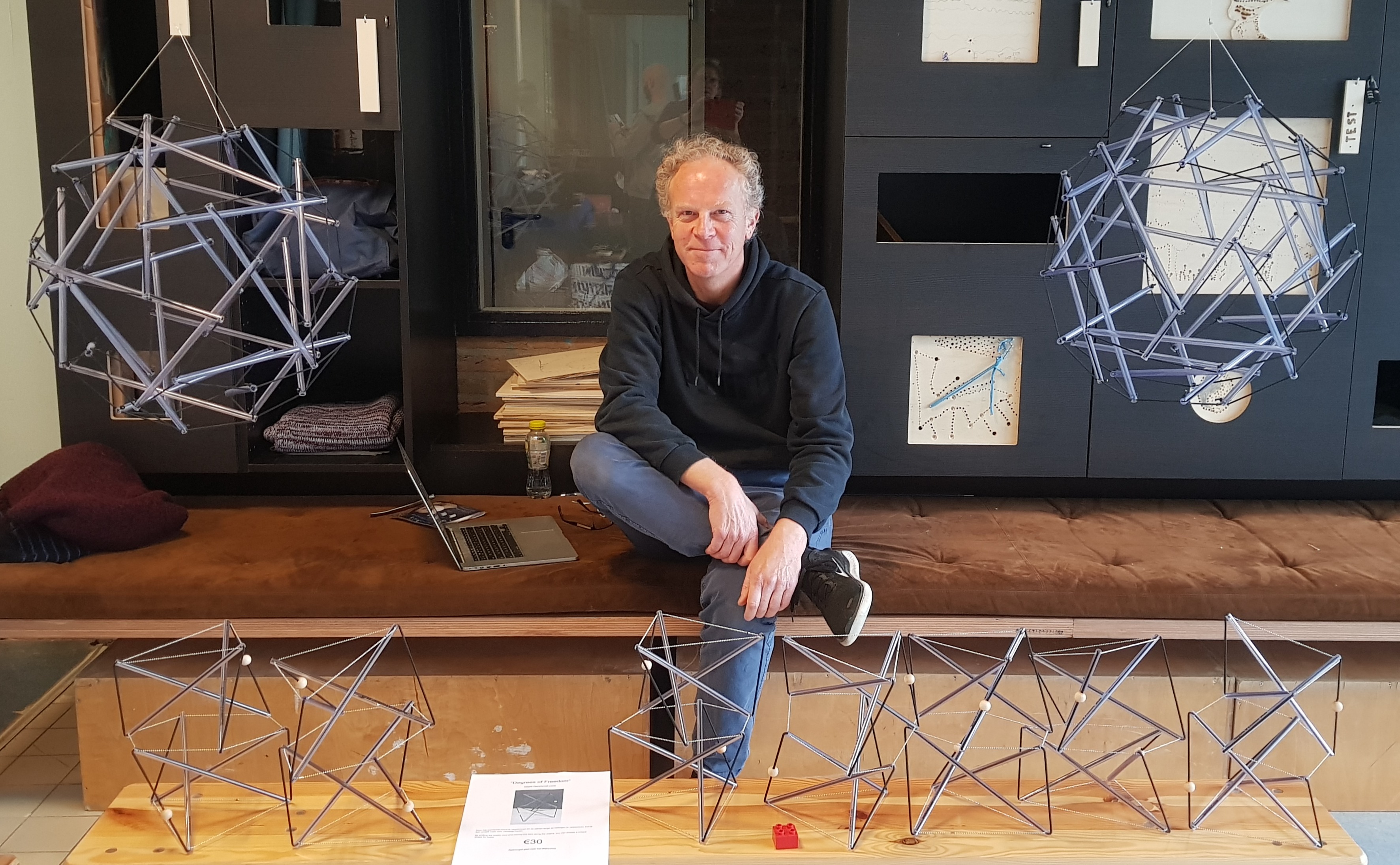 Gerald sitting with a laptop surrounded by a couple of tensegrity works.