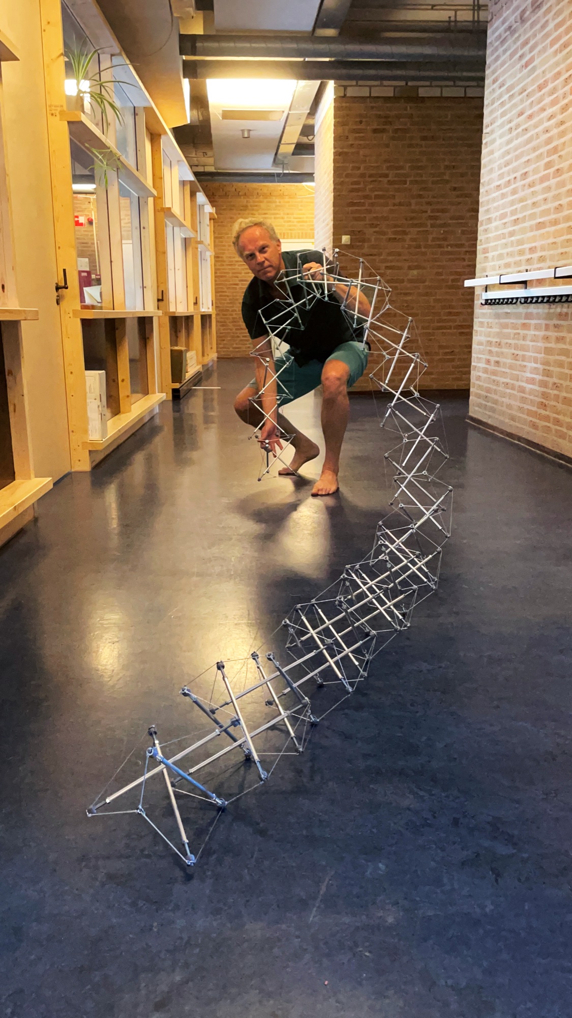 Gerald holding one end of a long horizontal tensegrity piece.